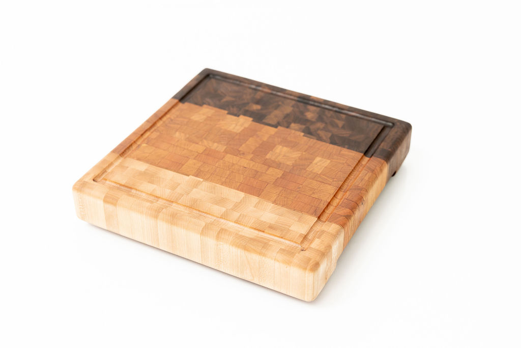 Handcrafted ombre end grain cutting board with gradient color transition from light maple to medium cherry to dark walnut, featuring juice groove and end grain butcher block construction