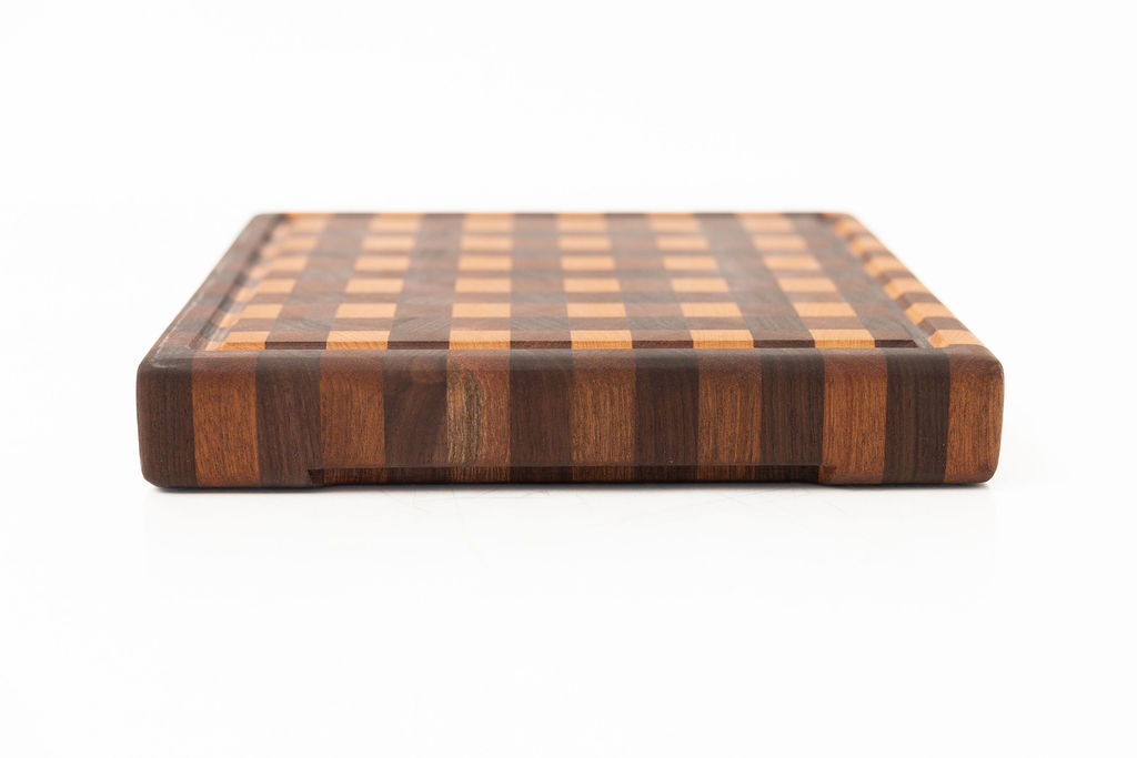 Gingham checkered pattern end grain cutting board featuring alternating squares of sapele, cherry, and walnut wood with juice groove and rounded corners