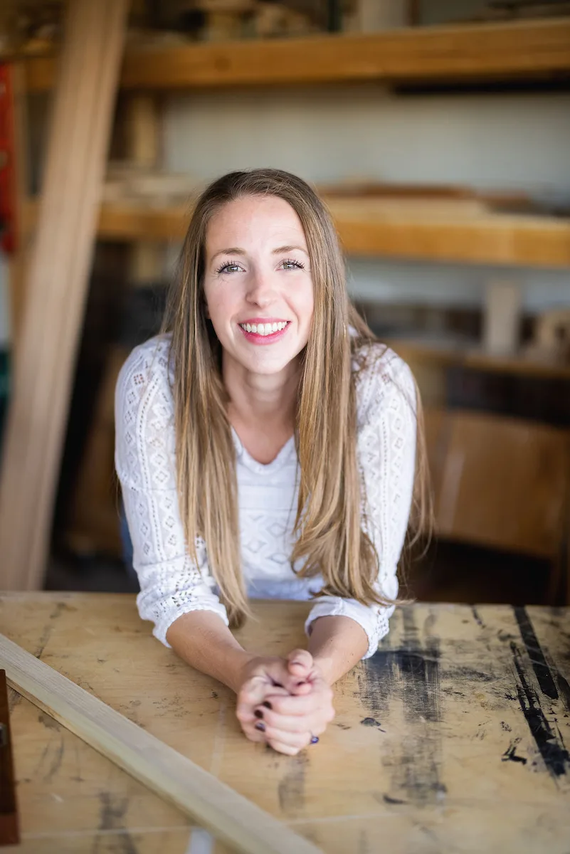Bethany, artisan furniture maker and owner of beth & co. woodworks, seated at her workbench in Sierra Vista, AZ