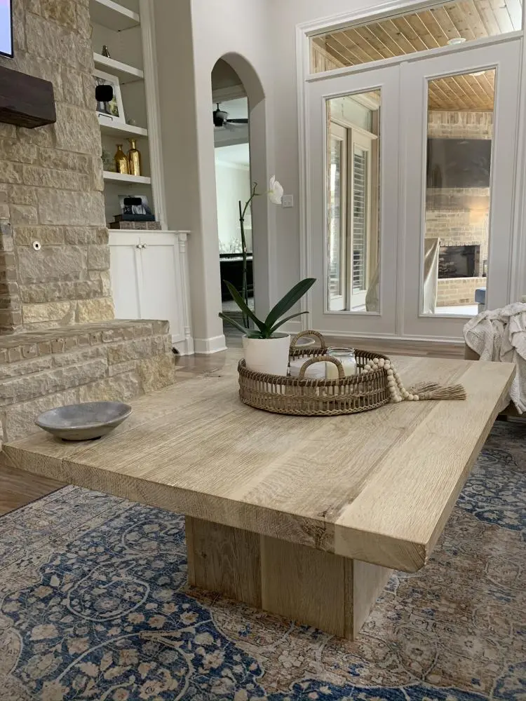 Staged view of a custom modern rustic coffee table in solid white oak with hand-scraped distressed surface, whitewash finish, and architectural plinth base — beth & co. woodworks, Sierra Vista, AZ